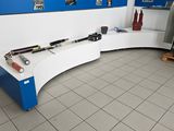 un plan de travail blanc sur lequel sont posés des outils, dans une pièce bleue et blanche