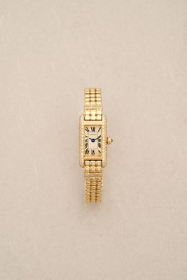 a close up of a watch on a white surface with a white background