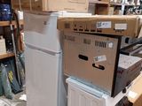 a stack of appliances and a washing machine in a warehouse