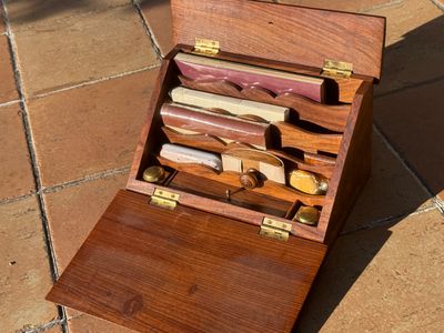 a wooden box with a bunch of knives inside of it