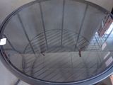 a round glass table with a metal frame on top of it