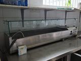 plan de travail en acier inoxydable dans une cuisine professionnelle dotée d'une vitrine en verre