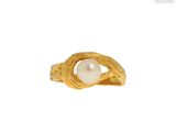 gros plan d'une bague en or contenant une perle