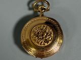 a gold pocket watch with a lion on it