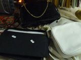 un ordinateur portable et un sac à main posés sur un lit, à côté d'une lampe