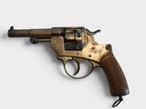 an old revolver with a wooden handle on a white surface