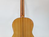 an acoustic guitar on a stand against a white background