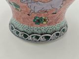 a vase with a horse on it sitting on a table
