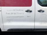 a white van with red writing on it parked in a parking lot
