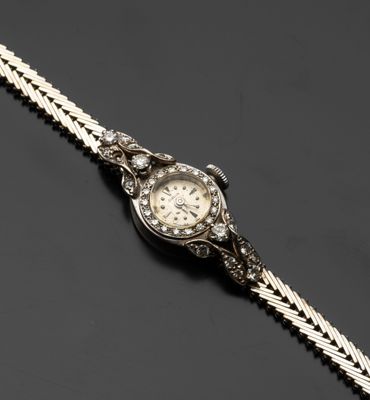 une montre-bracelet pour femme sertie de diamants, attachée à une chaîne