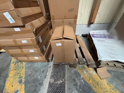 une pile de cartons posée par terre à côté d'une palette
