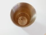 a metal bowl with a liquid inside of it on a table