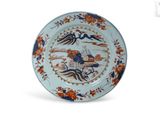 une assiette bleue et orange ornée d'un motif représentant un oiseau