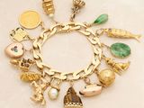 a gold bracelet with many different charms on it