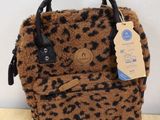 a close up of a leopard print bag on a wooden table