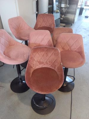 Plusieurs chaises roses sont alignées en rang dans une pièce