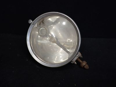 une assiette en argent sur laquelle repose une cuillère, posée sur un fond noir