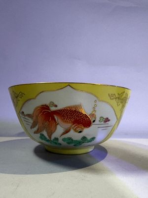 a bowl with a gold fish on it on a table
