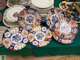 de nombreuses assiettes et bols posés sur une table recouverte d'une nappe verte