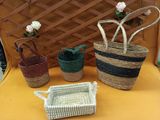 trois paniers posés sur une table, remplis de fleurs