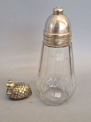 a glass salt and pepper shaker with a bird figurine next to it