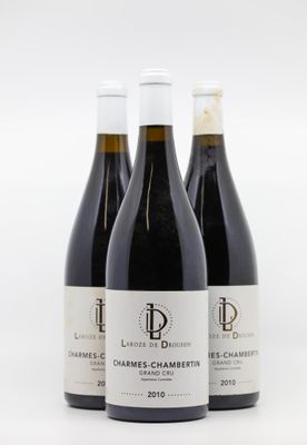 trois bouteilles de vin posées les unes à côté des autres sur une surface blanche