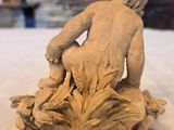 a statue of a boy sitting on top of a table