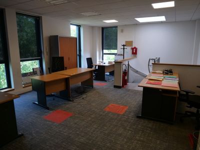 une pièce équipée d'un bureau, de chaises et d'une télévision