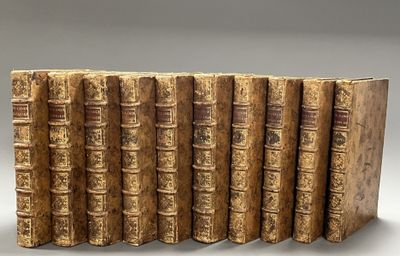 six old books lined up in a row on a white surface