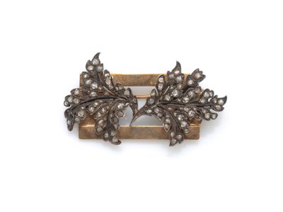 un gros plan d'une broche ornée d'un motif de feuille