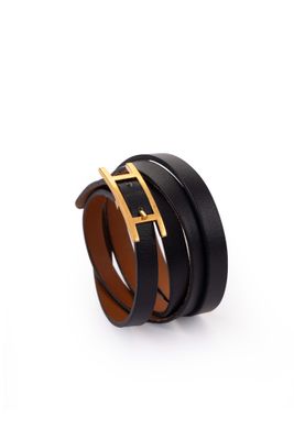 Gros plan sur une ceinture noire avec une boucle dorée