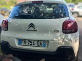a small white car parked on the side of the road