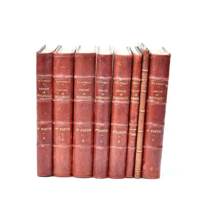several old books are stacked on top of each other on a white surface