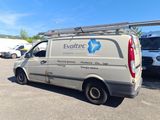 an image of a van parked in a parking lot with other vehicles in the background