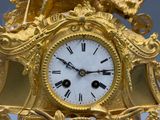 une horloge en or surmontée d'un oiseau