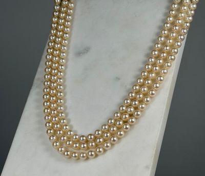a close up of a pearl necklace on a mannequin stand