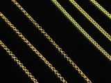 a close up of a row of gold chains on a black background
