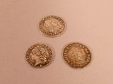 three different types of coins are shown on a white surface