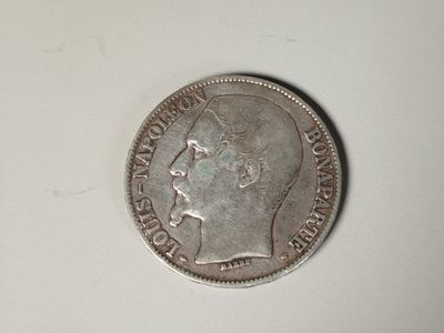 an old coin with a man ' s head on it on a white surface