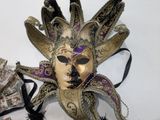 a gold mask with a purple and black design on it