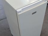 an image of a small white refrigerator in a warehouse
