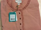 a pink shirt with a tag on it on a table