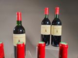 several bottles of red wine are lined up on a table