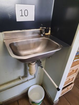 a sink in the corner of a room with a number 10 on the wall