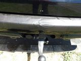 a close up of a car ' s rear end with a person standing in the background