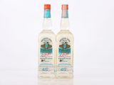 deux bouteilles d'alcool posées sur une surface blanche