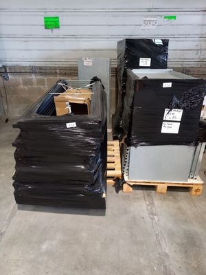 de nombreuses boîtes noires empilées sur une palette dans un entrepôt