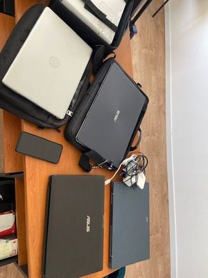 several laptops and other electronics are sitting on a wooden table