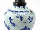 a blue and white vase with a lid on a white background