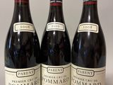 trois bouteilles de vin posées sur une table l'une à côté de l'autre